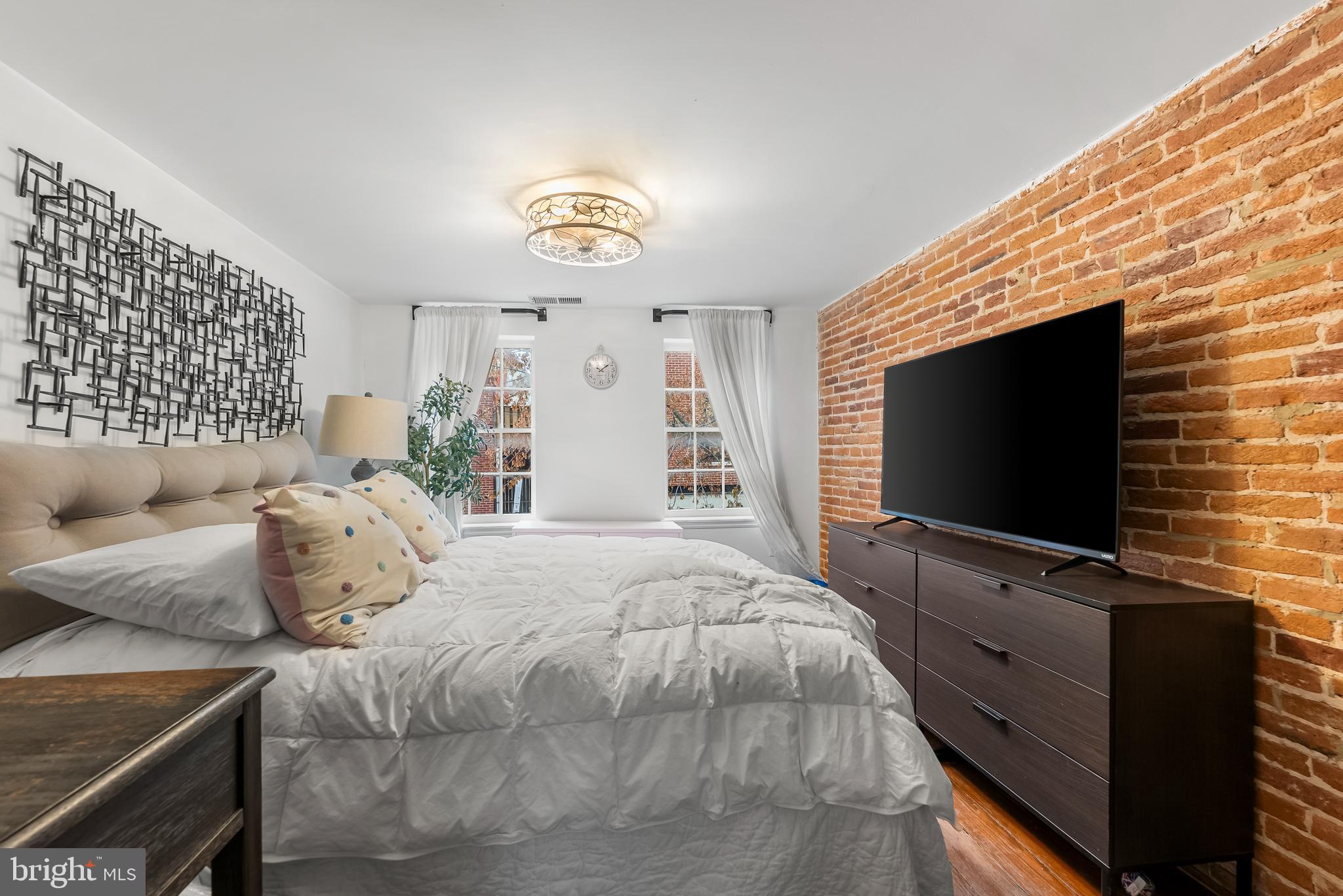 1812 Lancaster Street Baltimore, MD 21231 - Photo 11 of 38 a bedroom with a bed and a flat screen tv