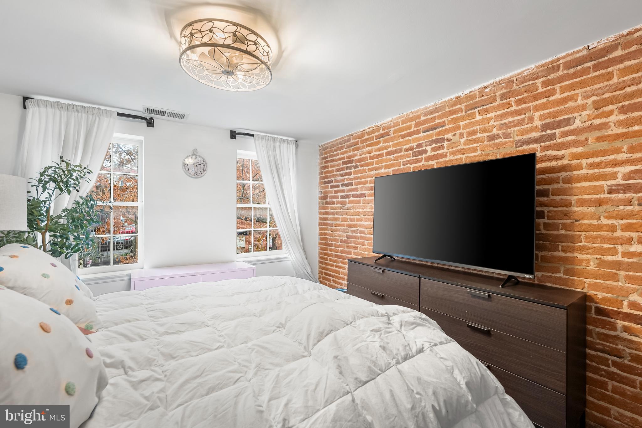 1812 Lancaster Street Baltimore, MD 21231 - Photo 12 of 38 a bedroom with a bed and a flat screen tv