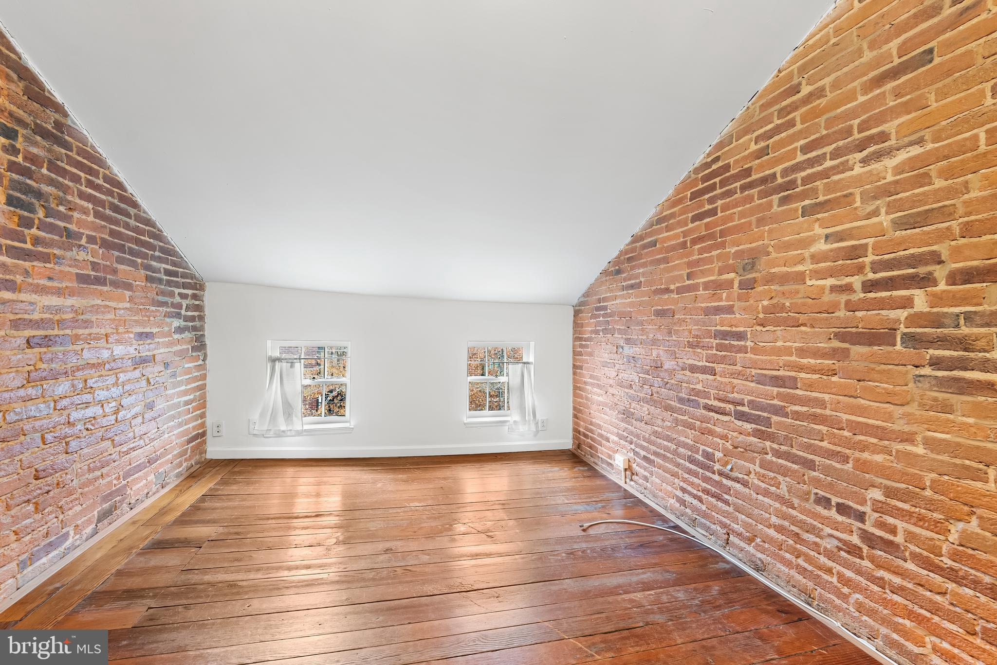 1812 Lancaster Street Baltimore, MD 21231 - Photo 23 of 38 a view of an empty room with wooden floor and a window