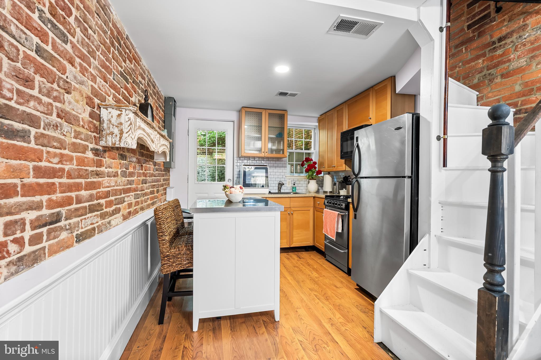 1812 Lancaster Street Baltimore, MD 21231 - Photo 5 of 38 a kitchen with a refrigerator a sink dishwasher and a stove with wooden floor