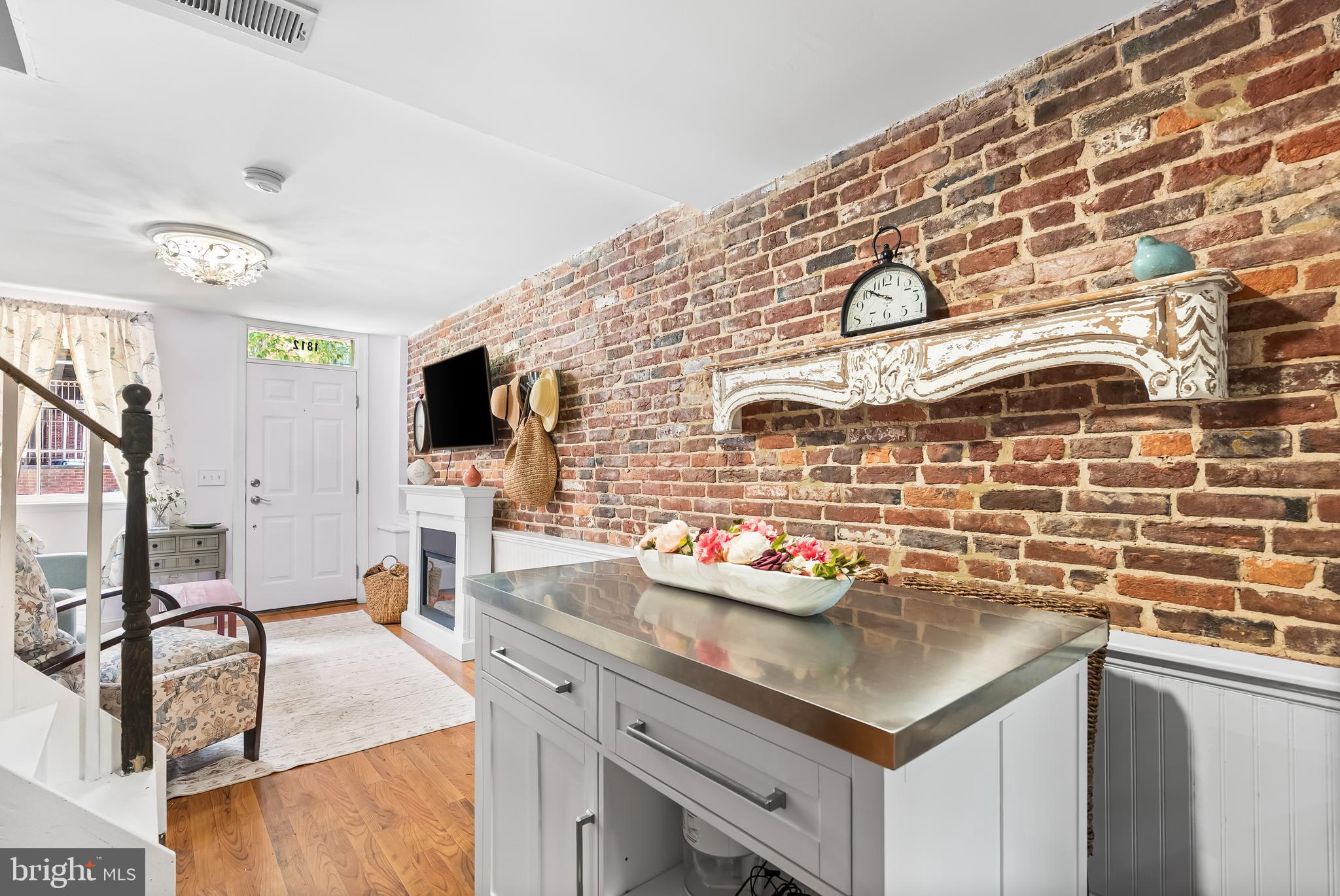 1812 Lancaster Street Baltimore, MD 21231 - Photo 6 of 38 a kitchen with stainless steel appliances kitchen island granite countertop a sink cabinets and wooden floor