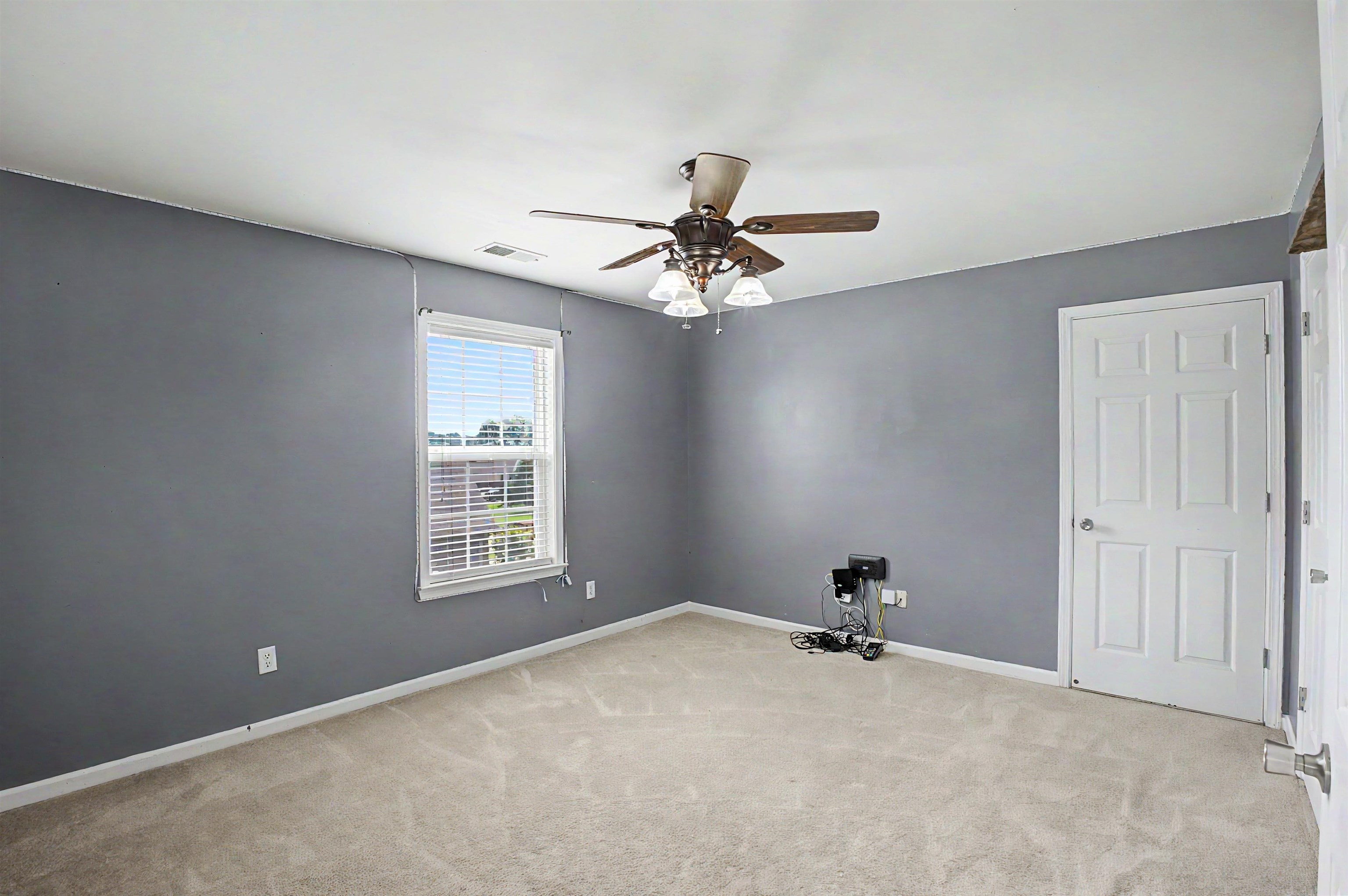 134 Rembert Drive Atoka, TN 38004 - Photo 30 of 38 Carpeted room with a ceiling fan light fixture, white trim, a single window with horizontal blinds, and a paneled white door