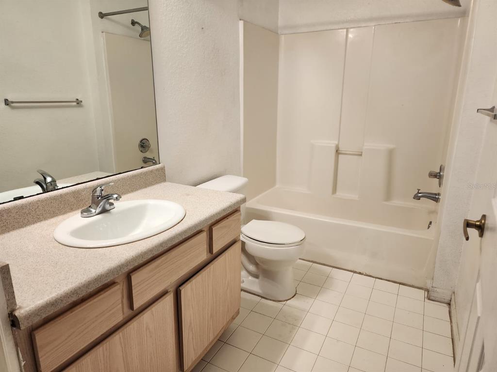 5483 Vineland Road, Unit 10107 Orlando, FL 32811 - Photo 12 of 17 a bathroom with a sink toilet and shower