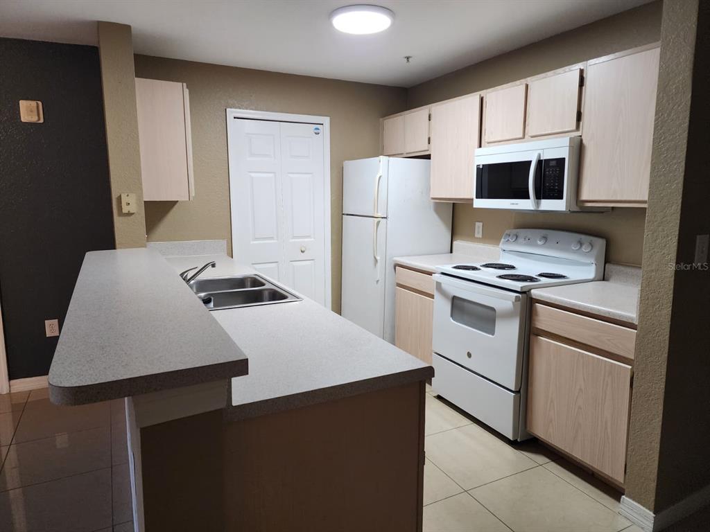 5483 Vineland Road, Unit 10107 Orlando, FL 32811 - Photo 3 of 17 a kitchen that has a cabinets and a stove