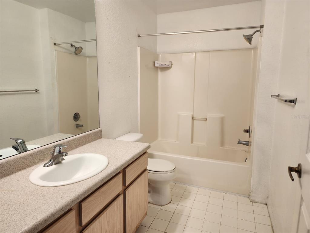 5483 Vineland Road, Unit 10107 Orlando, FL 32811 - Photo 5 of 17 a bathroom with a sink toilet a mirror and shower