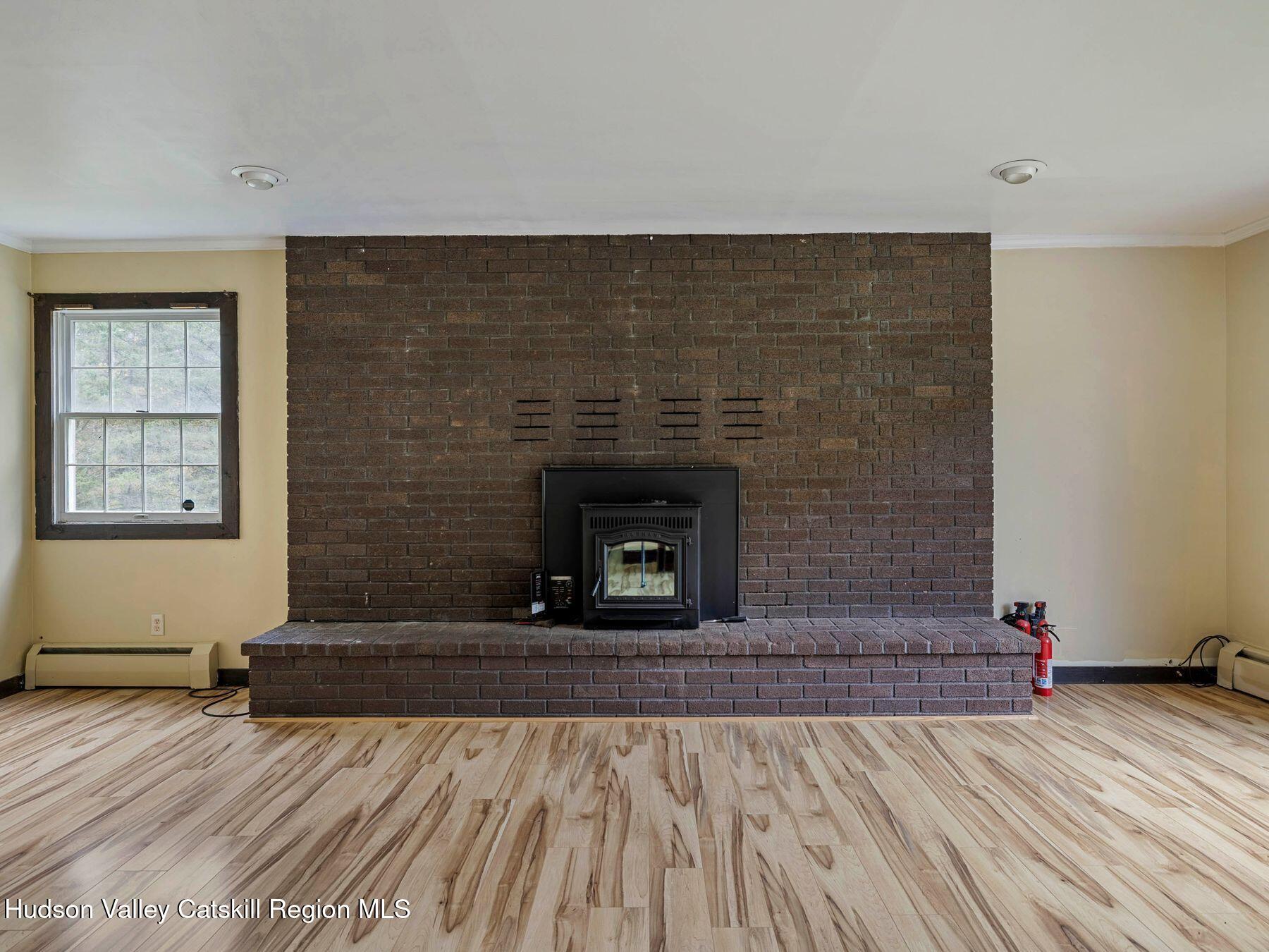 317 Mitchell Hollow Road Windham, NY 12496 - Photo 12 of 41 a view of empty room with wooden floor and fireplace
