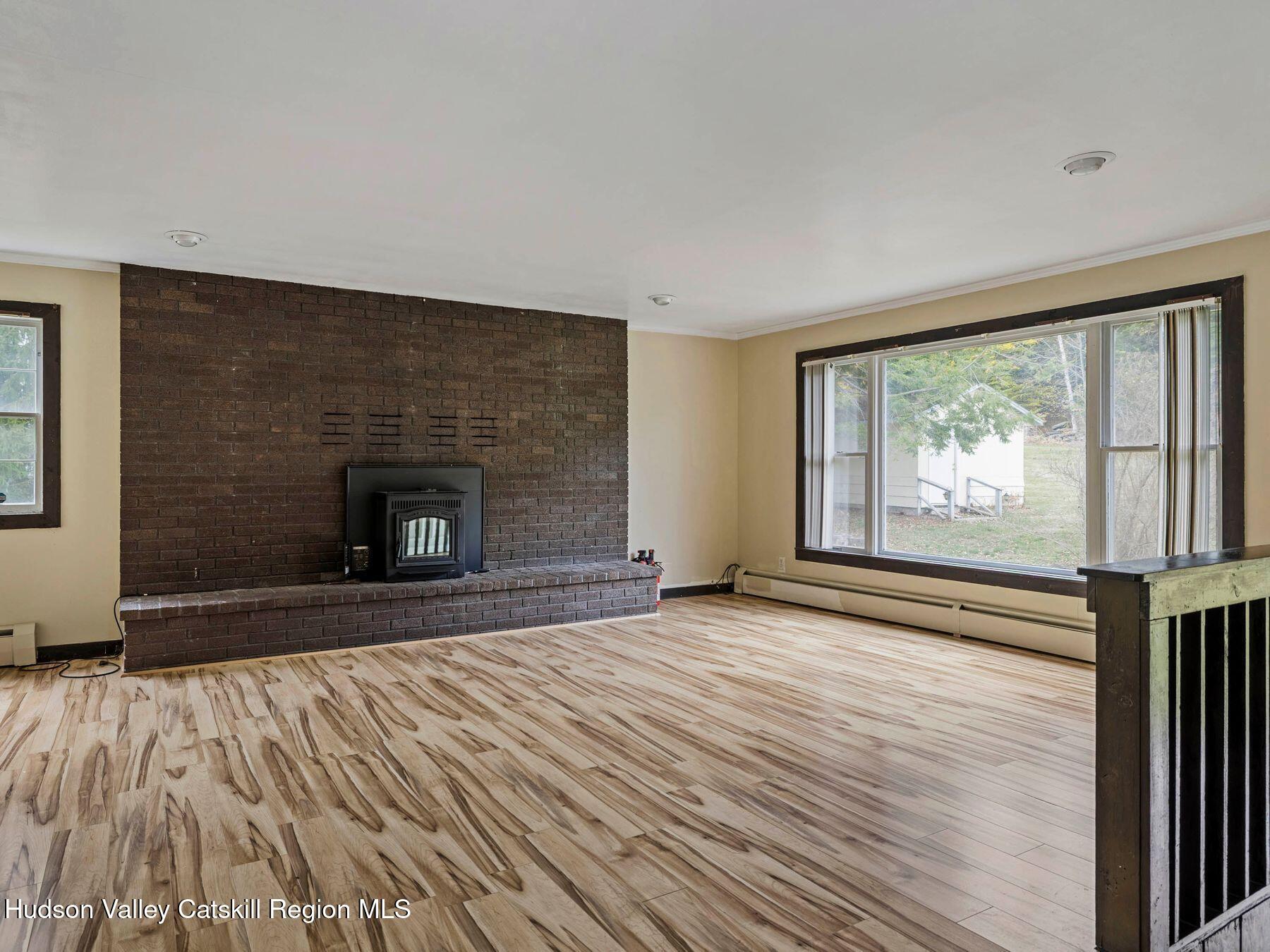 317 Mitchell Hollow Road Windham, NY 12496 - Photo 13 of 41 a view of empty room with wooden floor and fireplace
