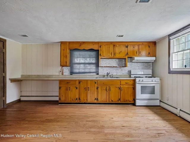 a view of a room with wooden floor and a ceiling fan
