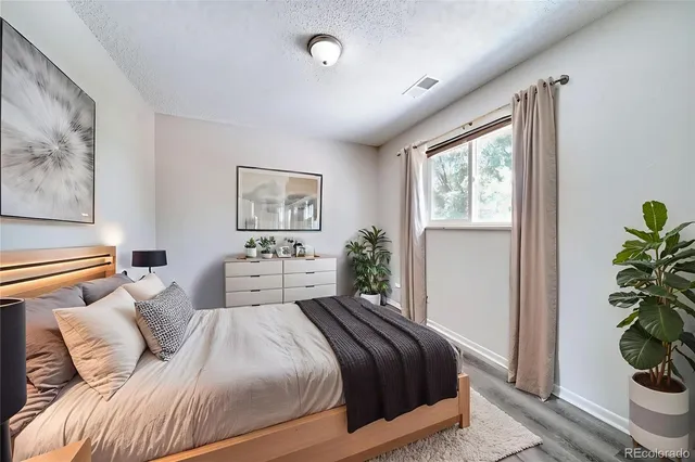 a bedroom with a large bed and a potted plant