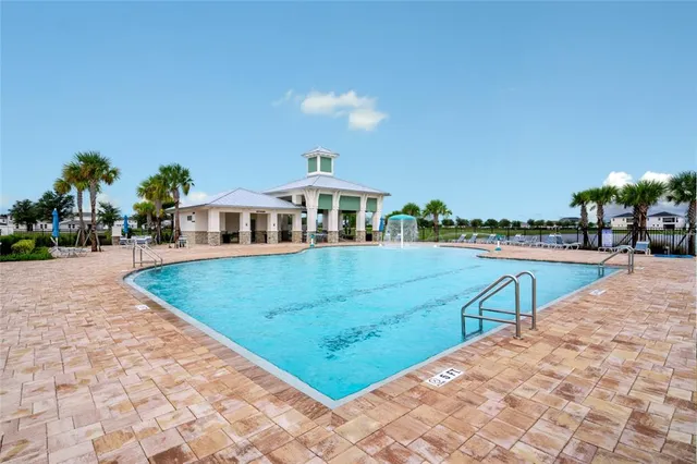 a view of a house with swimming pool and next to a yard