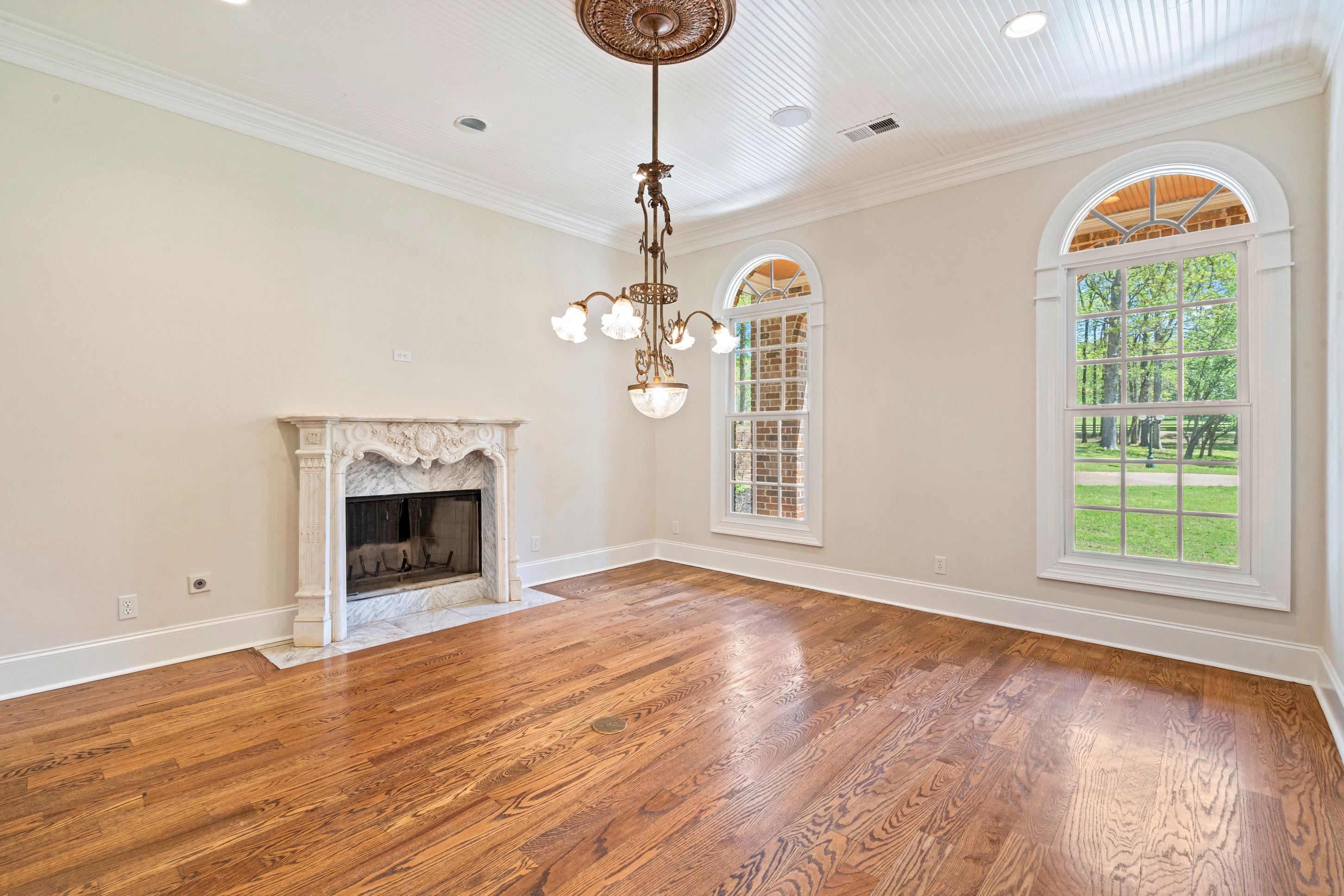 815 Dent Road Eads, TN 38028 - Photo 9 of 40 Unfurnished living room featuring wood finished floors, ornamental molding, a fireplace, and a chandelier