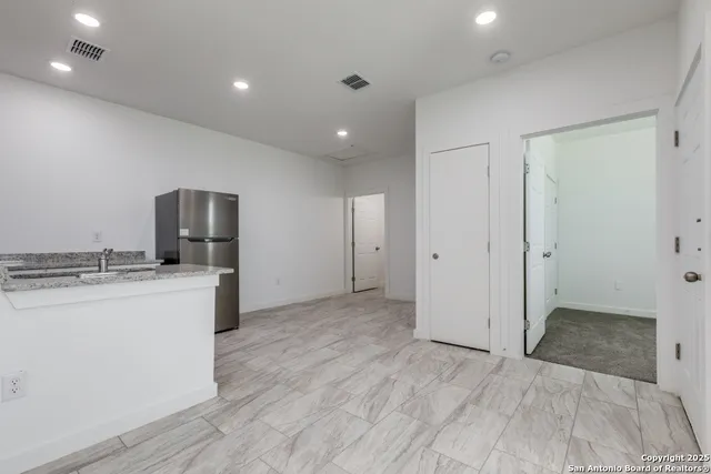 a view of kitchen with stainless steel appliances granite countertop cabinets and wooden floor