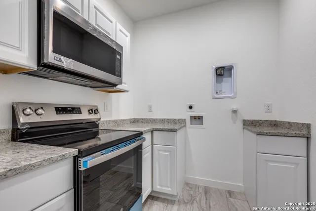 a kitchen with stainless steel appliances granite countertop a stove and a microwave