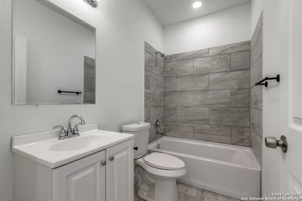 a bathroom with a sink mirror toilet and bathtub