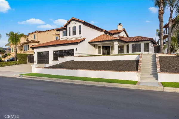 a front view of a house with a garden and yard