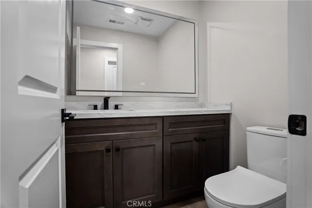a bathroom with a sink a toilet a mirror and vanity