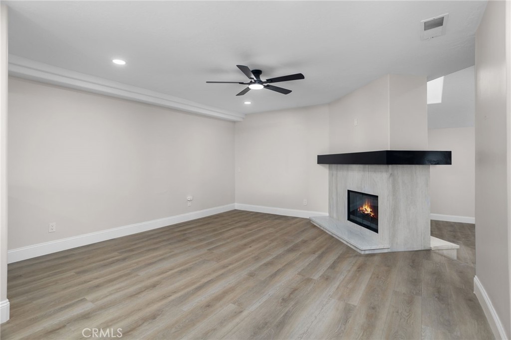 29566 Big Range Road, Unit 1 Canyon Lake, CA 92587 - Photo 24 of 55 an empty room with a fireplace and a ceiling fan