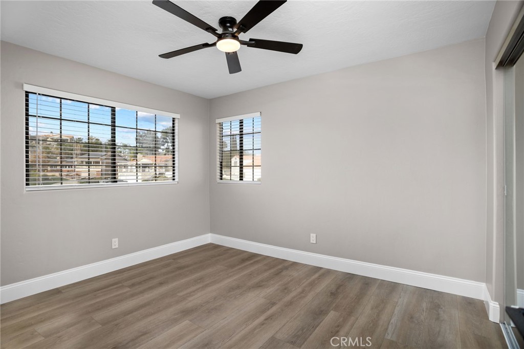 29566 Big Range Road, Unit 1 Canyon Lake, CA 92587 - Photo 28 of 55 an empty room with wooden floor ceiling fan and windows