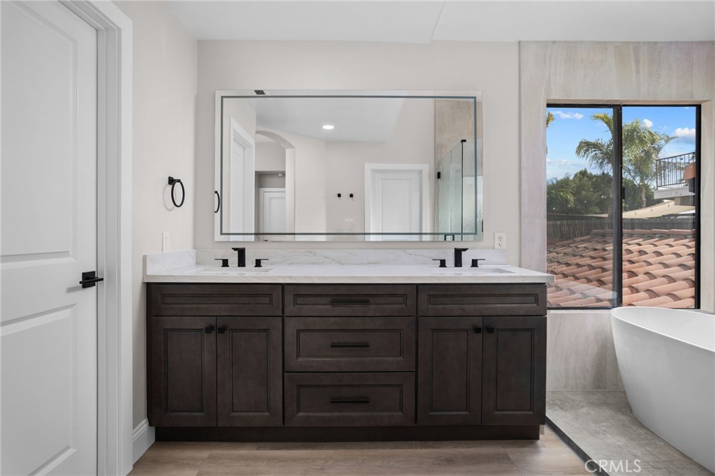 29566 Big Range Road, Unit 1 Canyon Lake, CA 92587 - Photo 40 of 55 a bathroom with a double vanity sink a large mirror and a bathtub