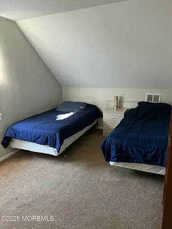 a spacious bedroom with a bed and a lamp on desk