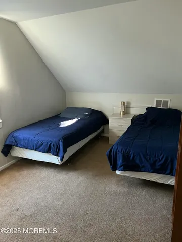 a spacious bedroom with a bed and a lamp on desk