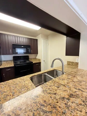 a kitchen with granite countertop a stove and a sink