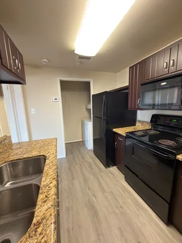 a kitchen with stainless steel appliances granite countertop a refrigerator and a stove top oven