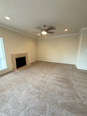 an empty room with a ceiling fan and window
