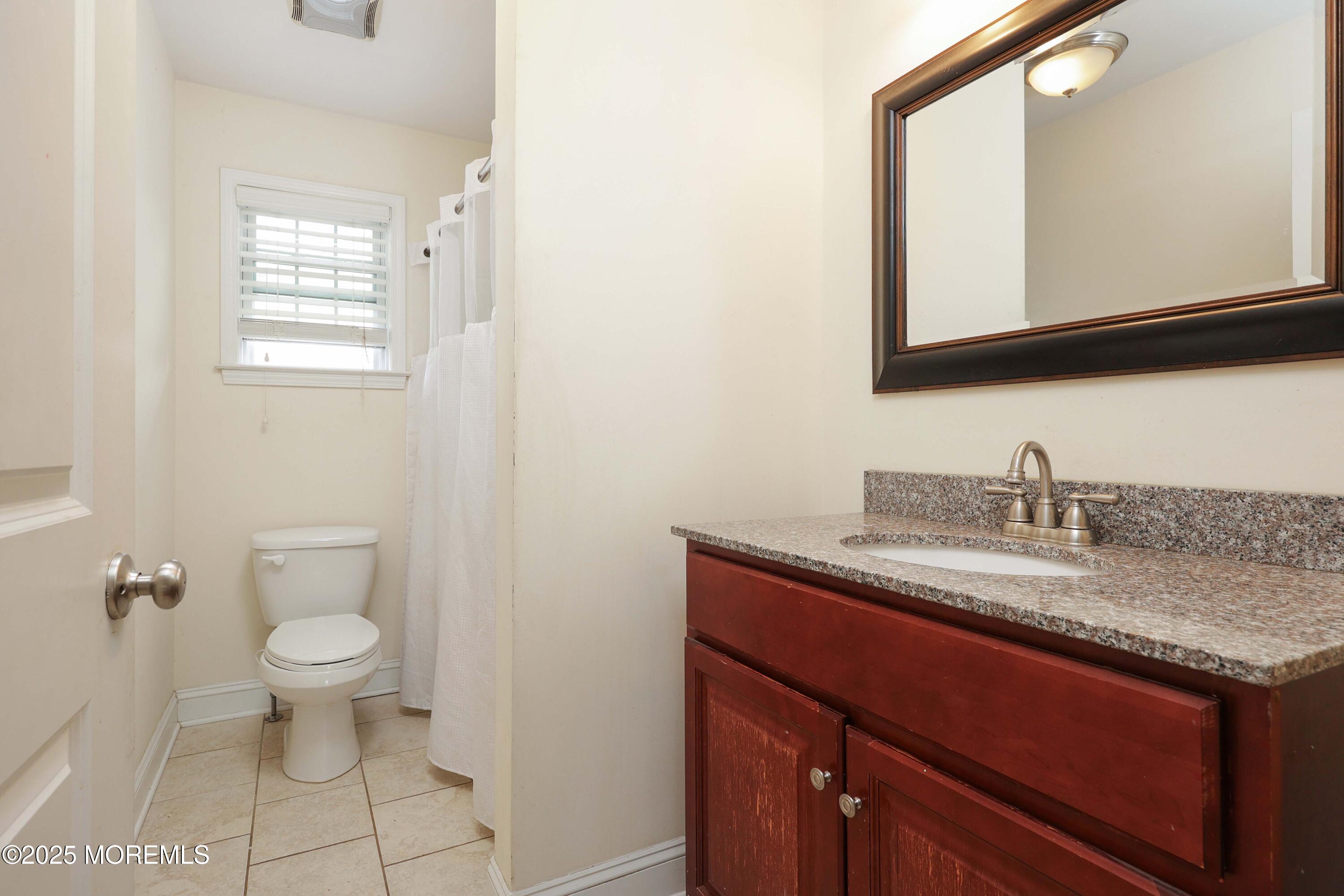 280 Linden Avenue Middletown, NJ 07748 - Photo 17 of 17 a bathroom with a granite countertop sink a large mirror and a toilet