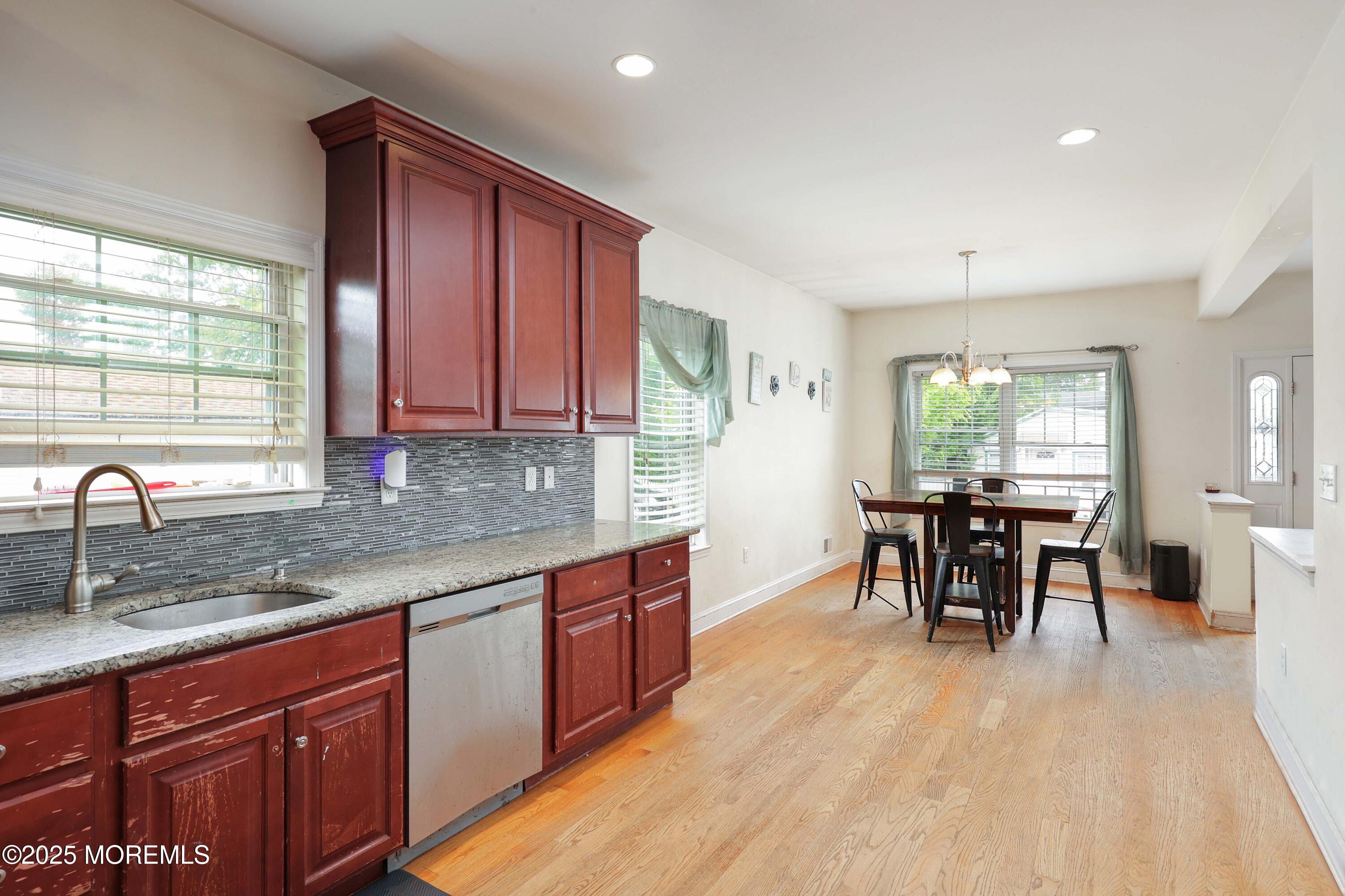 280 Linden Avenue Middletown, NJ 07748 - Photo 4 of 17 a kitchen with stainless steel appliances granite countertop sink window dining table and chairs