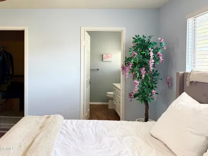 a bedroom with a bed and a potted plant