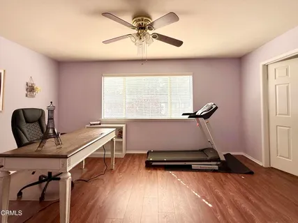 a room with gym equipment on wooden floor