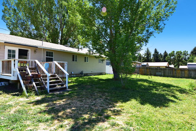 315 Park Street Inkom, ID 83245 - Photo 25 of 28 Expansive backyard featuring a mature shade tree and a wooden privacy fence