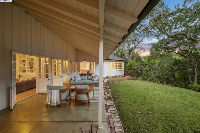 a view of a patio with table and chairs potted plants with floor to ceiling window