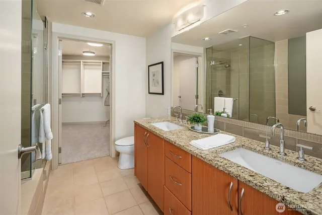 a bathroom with a granite countertop sink toilet and shower
