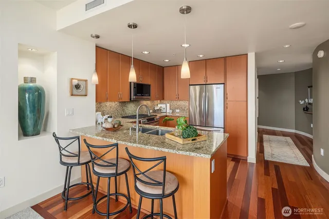 a kitchen with stainless steel appliances granite countertop a refrigerator and a stove top oven