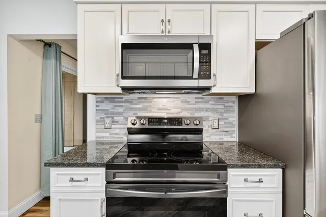 a kitchen with granite countertop a sink stove and refrigerator
