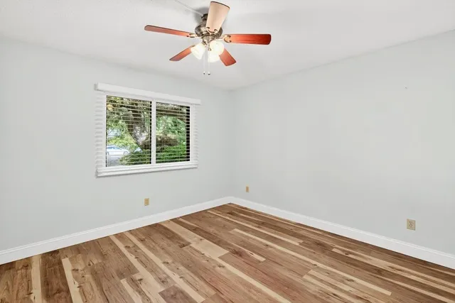 an empty room with a window and a fan