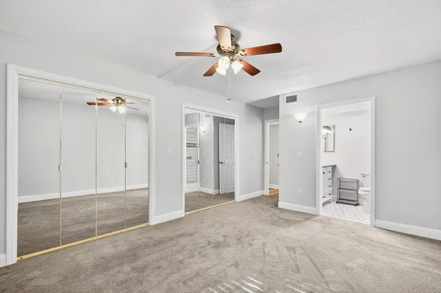 a bathroom with a granite countertop toilet sink and mirror