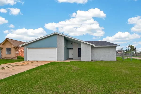 a view of a house with a yard and a garage