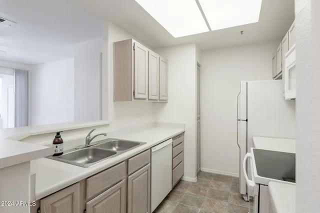 a kitchen with stainless steel appliances granite countertop a sink stove refrigerator and cabinets