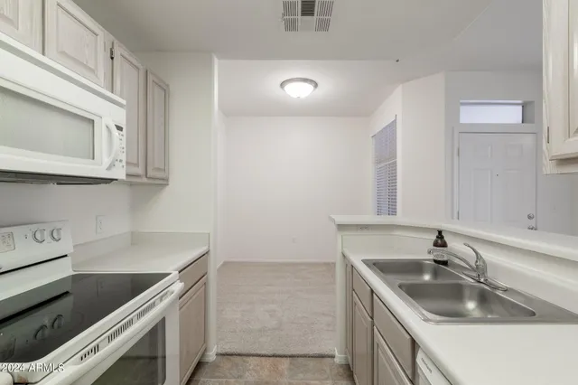 a view of an empty room with a chandelier fan