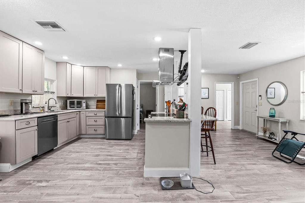 6244 Colony Circle Weeki Wachee, FL 34607 - Photo 38 of 60 a kitchen with sink a refrigerator and chairs