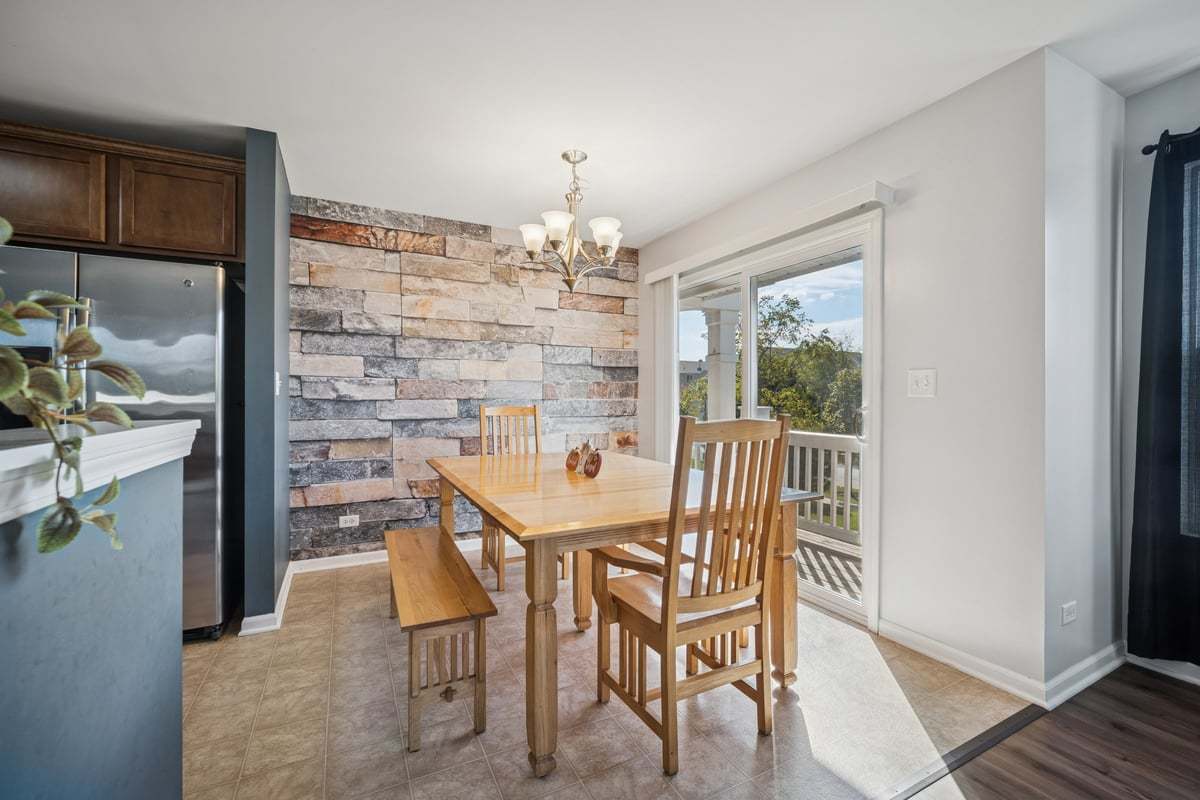 1701 Windward Drive Pingree Grove, IL 60140 - Photo 4 of 19 a dining room with furniture a chandelier and wooden floor