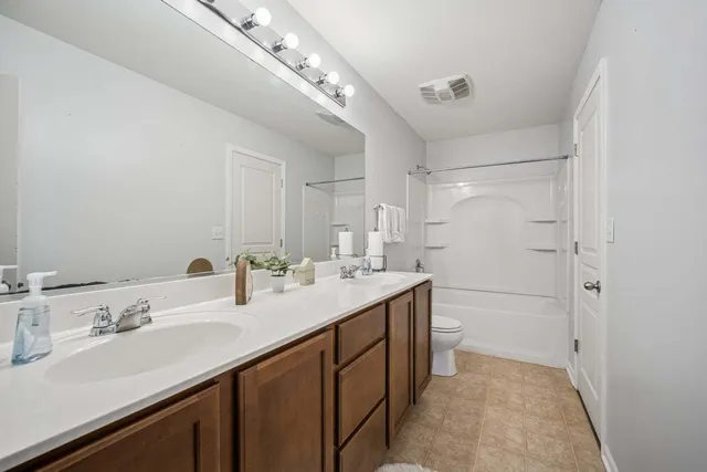 a bathroom with a double vanity sink mirror and shower