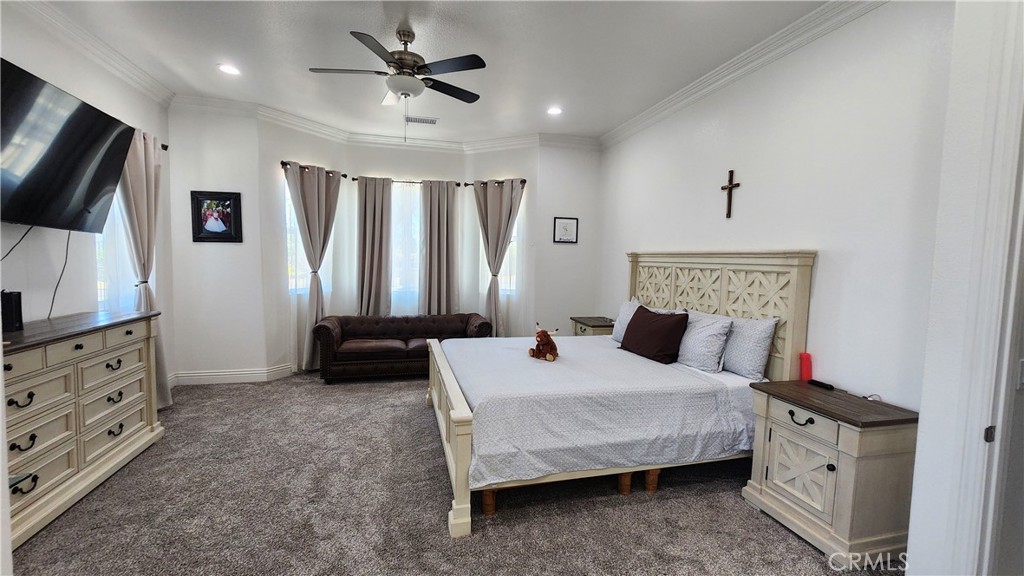 20243 Lee Road Perris, CA 92570 - Photo 31 of 75 a bedroom with a large bed and a flat tv screen on dresser