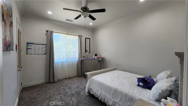 a bedroom with two beds and ceiling fan