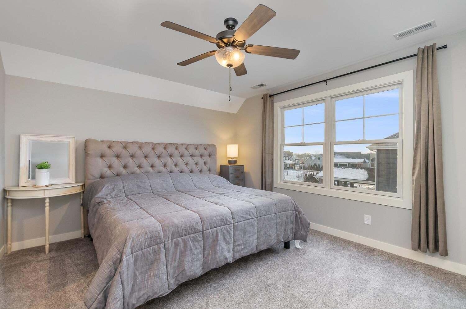 16617 Noble Street Lowell, IN 46356 - Photo 27 of 32 a bedroom with a large bed and a chandelier fan