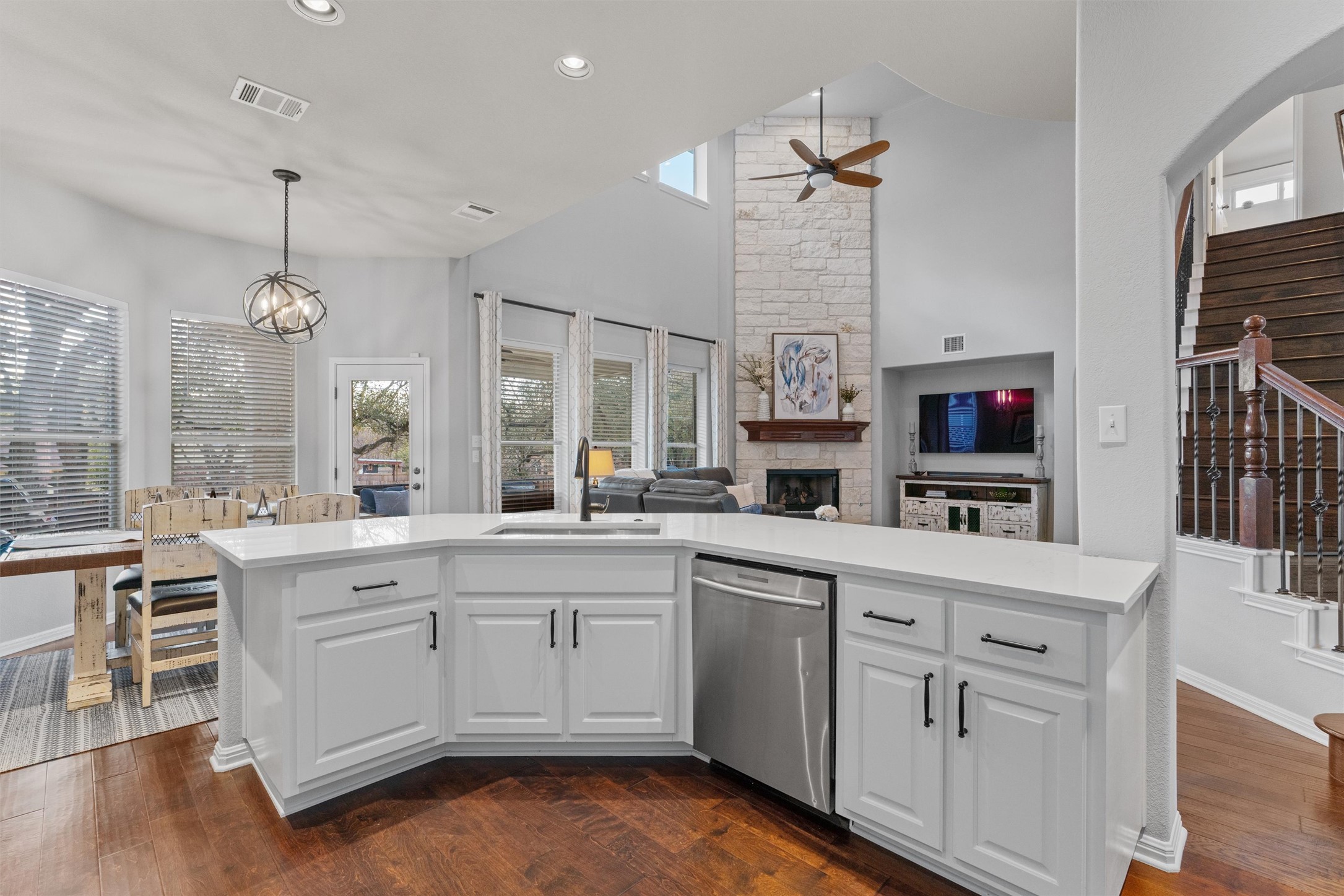 3736 Cerulean Way Round Rock, TX 78681 - Photo 35 of 36 Kitchen with a stone fireplace, stainless steel dishwasher, ceiling fan, white cabinetry, and open floor plan