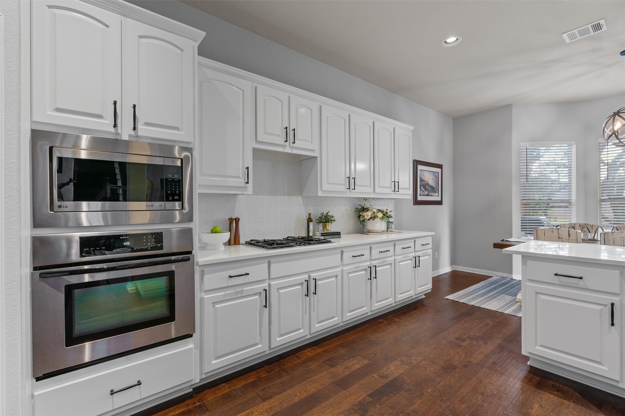3736 Cerulean Way Round Rock, TX 78681 - Photo 12 of 36 Kitchen with white cabinetry, stainless steel appliances, and dark wood finished floors